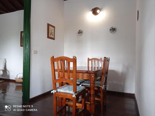 une table à manger avec deux chaises et une lumière sur le mur dans l'établissement Casa PESTANA, à Fuencaliente de la Palma
