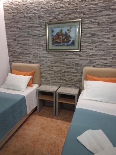 a room with two beds and a brick wall at Loutro Holidays in Loutro