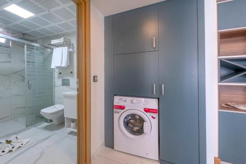a bathroom with a washing machine and a toilet at TheLuna Suite Hotel in Antalya