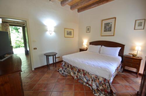 a bedroom with a bed and a television in it at Hotel Villa Luppis in Pasiano di Pordenone