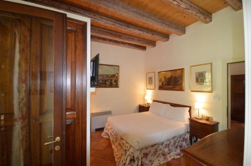 a bedroom with a bed and a wooden door at Hotel Villa Luppis in Pasiano di Pordenone