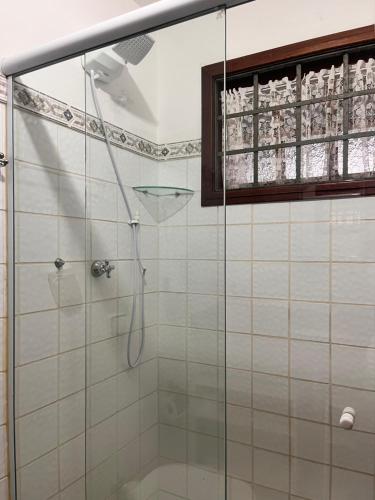 een badkamer met een douche met een glazen deur bij Delphin Apartamento 8 in Ilhabela