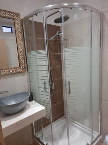a bathroom with a glass shower with a sink at Loutro Holidays in Loutro