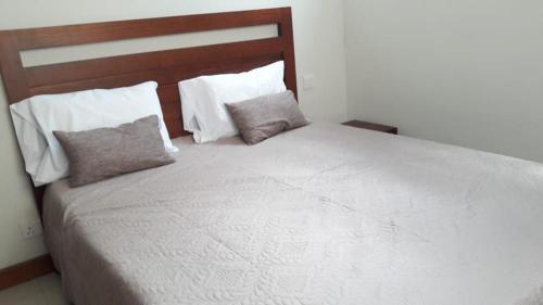una camera da letto con un grande letto bianco con due cuscini di Villa Jaya a Flic-en-Flac