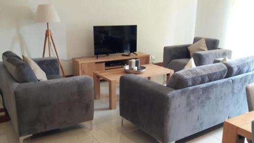 un soggiorno con 2 divani e una TV di Villa Jaya a Flic-en-Flac