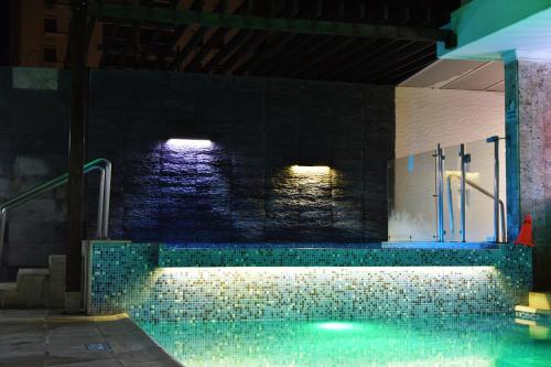 a swimming pool in a building with a tile floor at Hotel La Riviera in Santa Marta