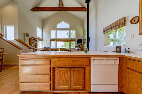 a kitchen with wooden cabinets and a white dishwasher at Ocean Song in Shelter Cove