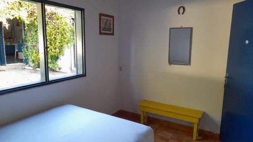 a bedroom with a bed and a window and a bench at PiriHost no Centro da cidade in Pirenópolis