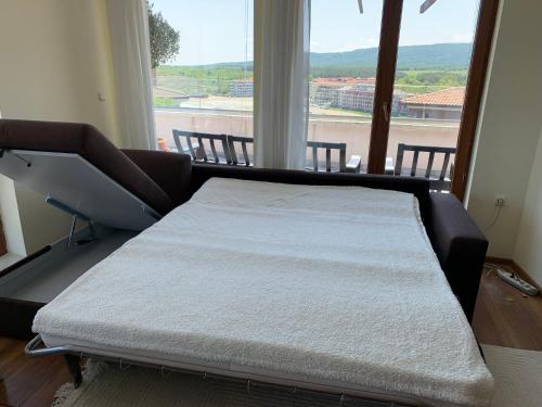 a bed in a room with a large window at Magic Sea View in Tsarevo