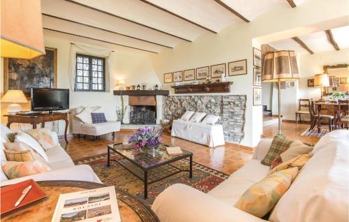 a living room with white furniture and a stone fireplace at Il Seminario in Collevecchio