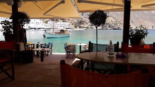 
a patio area with tables, chairs and umbrellas at Loutro Holidays in Loutro
