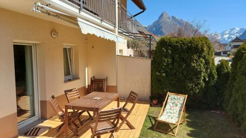a patio with a wooden table and chairs on a porch at APARTMA GONZO in Bovec