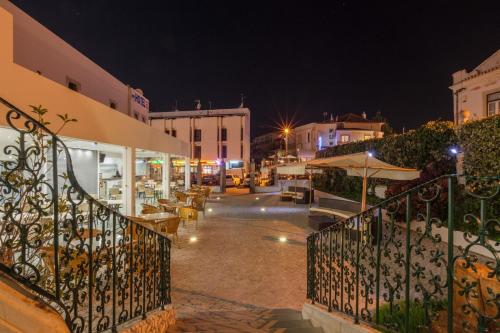 a city street at night with tables and umbrellas at Vila Recife Hotel in Albufeira