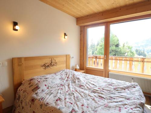 een slaapkamer met een bed en een groot raam bij Appartement Les Gets, 2 pièces, 5 personnes - FR-1-623-203 in Les Gets