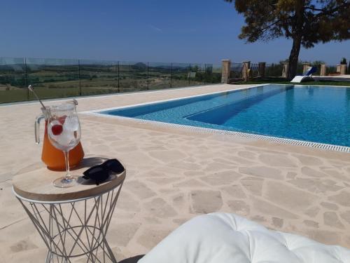a drink on a table next to a swimming pool at Mater Ariany in Ariany