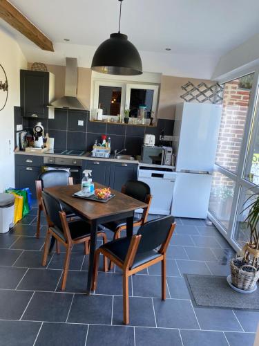 a kitchen with a table and chairs in a kitchen at LE GAI LO GITE in Villers-Pol