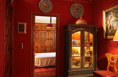 a red room with a bed and a mirror at Almunia de San Miguel in Toledo