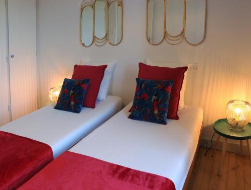 two beds in a room with red and white at Le gîte de la glycine in Palmas