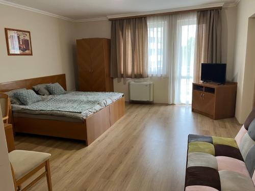 a bedroom with two beds and a television in it at Brookforest Apartman in Hajdúszoboszló