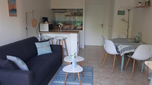 un salon avec un canapé et une table dans l'établissement Bleu Soleil 3* en résidence 200m plage & commerces, à Saint-Georges-de-Didonne