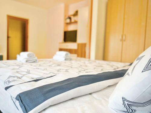 a large white bed with blue and white sheets at Sunny Central Apartment with TV & Wi-Fi in Stara Zagora
