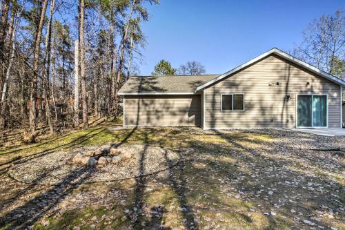 a home in the woods with a large yard at Breezy Point Cabin with Fire Pit - Walk to Lake in Breezy Point
