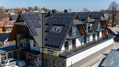une rangée de maisons avec des panneaux solaires sur leur toit dans l'établissement Apartamenty Hyrczyk, à Ząb
