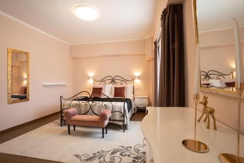 a bedroom with a bed and a chair and a mirror at Il Castellaccio in Spello