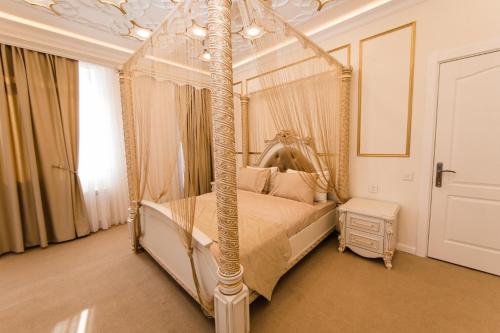 a bedroom with a four poster canopy bed at Alfa Hotel in Baku