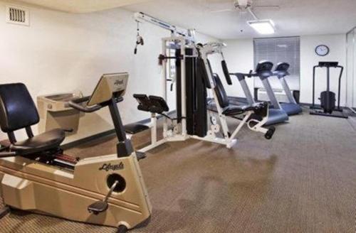 a gym with several treadmills and machines in a room at Ramada by Wyndham Gainesville in Gainesville