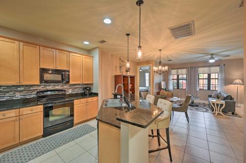 a kitchen with wooden cabinets and a living room at Naples Resort Townhome with Endless Amenities! in Lely Resort