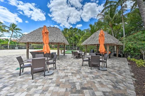 a patio with tables and chairs and umbrellas at Naples Resort Townhome with Endless Amenities! in Lely Resort