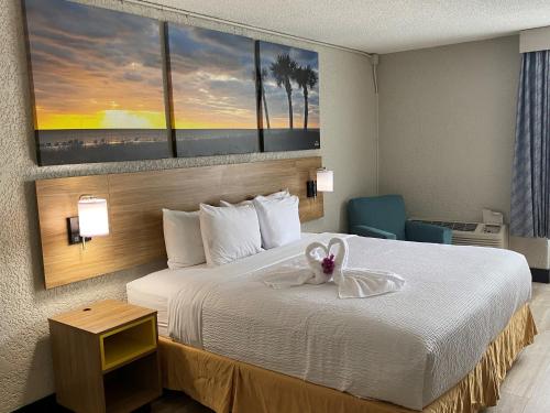 a hotel room with a bed with a bow on it at Days Inn by Wyndham Fort Pierce Midtown in Fort Pierce