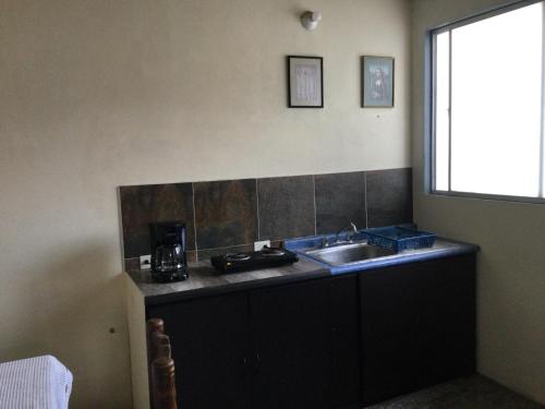 a kitchen with a sink and a coffee maker on a counter at Trotamundo Oaxaca Hostel in Oaxaca City