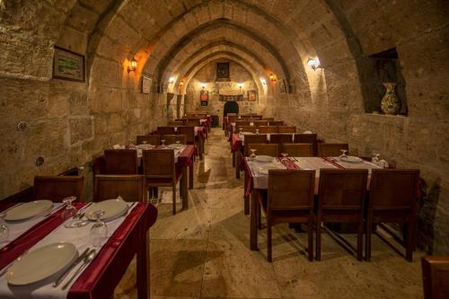 a dining room with tables and chairs in a building at Karamanli Konagi in Guzelyurt