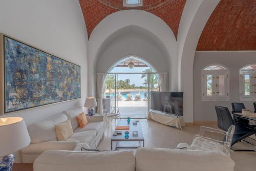 a living room with white couches and a tv at VESTA - El Gouna Residence in Hurghada