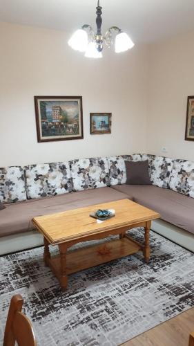 um sofá com uma mesa de madeira numa sala de estar em Valentina's Apartment em Tirana