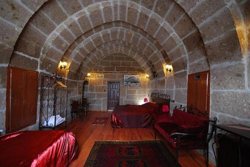 a large room with a bed and a stone wall at Karamanli Konagi in Guzelyurt