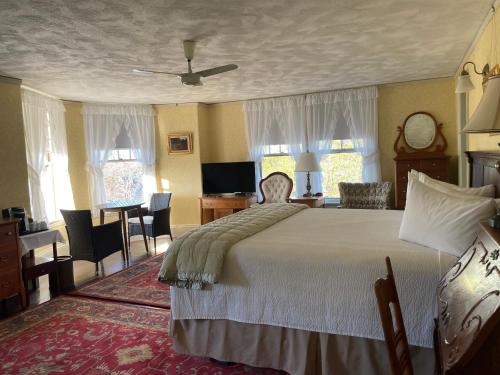 a hotel room with a large bed and a large window at Moseley Cottage Inn and The Town Motel in Bar Harbor