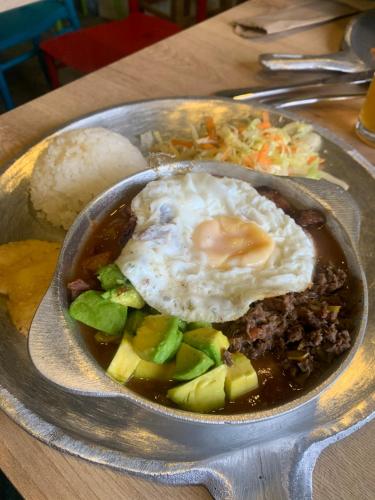 a bowl of food with a fried egg on a table at La posada de Rubi in Salento