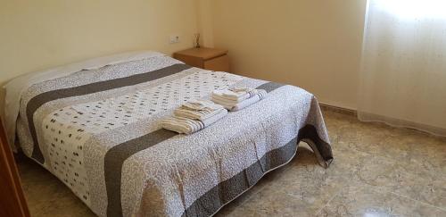 een slaapkamer met een bed met twee handdoeken erop bij Habitación Tranquila, Agradable cerca de Valencia en Vivienda Compartida in Paterna