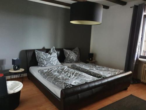 a bed in a room with a black leather couch at Schöne Aussicht in Nettersheim
