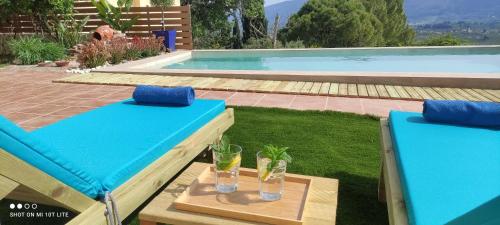 a blue table with two glasses on it next to a swimming pool at Villa Pigi in Meson Yerakarion