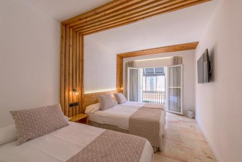 a hotel room with two beds and a balcony at Hotel Boutique Sibarys - Adults Recommended in Nerja