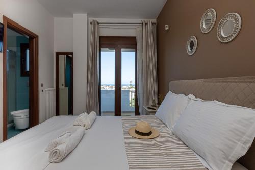 1 dormitorio con 1 cama con sombrero en Thalasinos Luxury Villa, en Gournes
