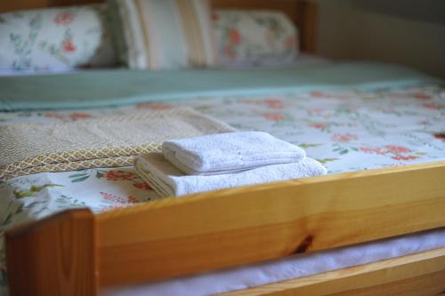 a bed with two towels sitting on top of it at Penzion Dvůr in Obora