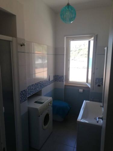 een badkamer met een wasmachine en een raam bij CASA BELLAVISTA in Nicotera