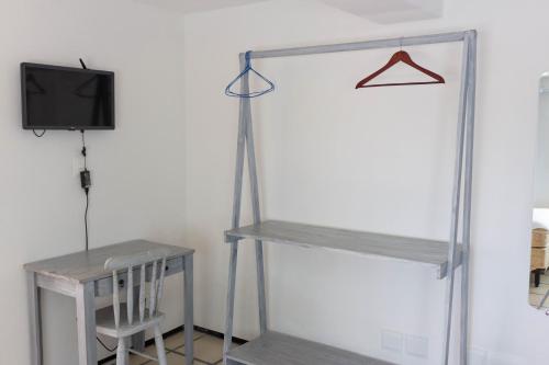 a room with two shelves and a tv and a table at Sonho de Iracema Hostel Boutique in Fortaleza