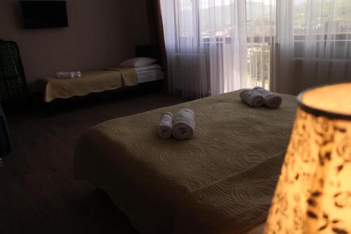 a hotel room with a bed with slippers on it at Hotel Rabati in Akhaltsikhe