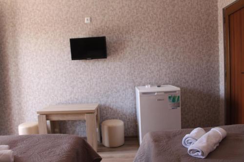 a room with a refrigerator and a tv on the wall at Hotel Rabati in Akhaltsikhe